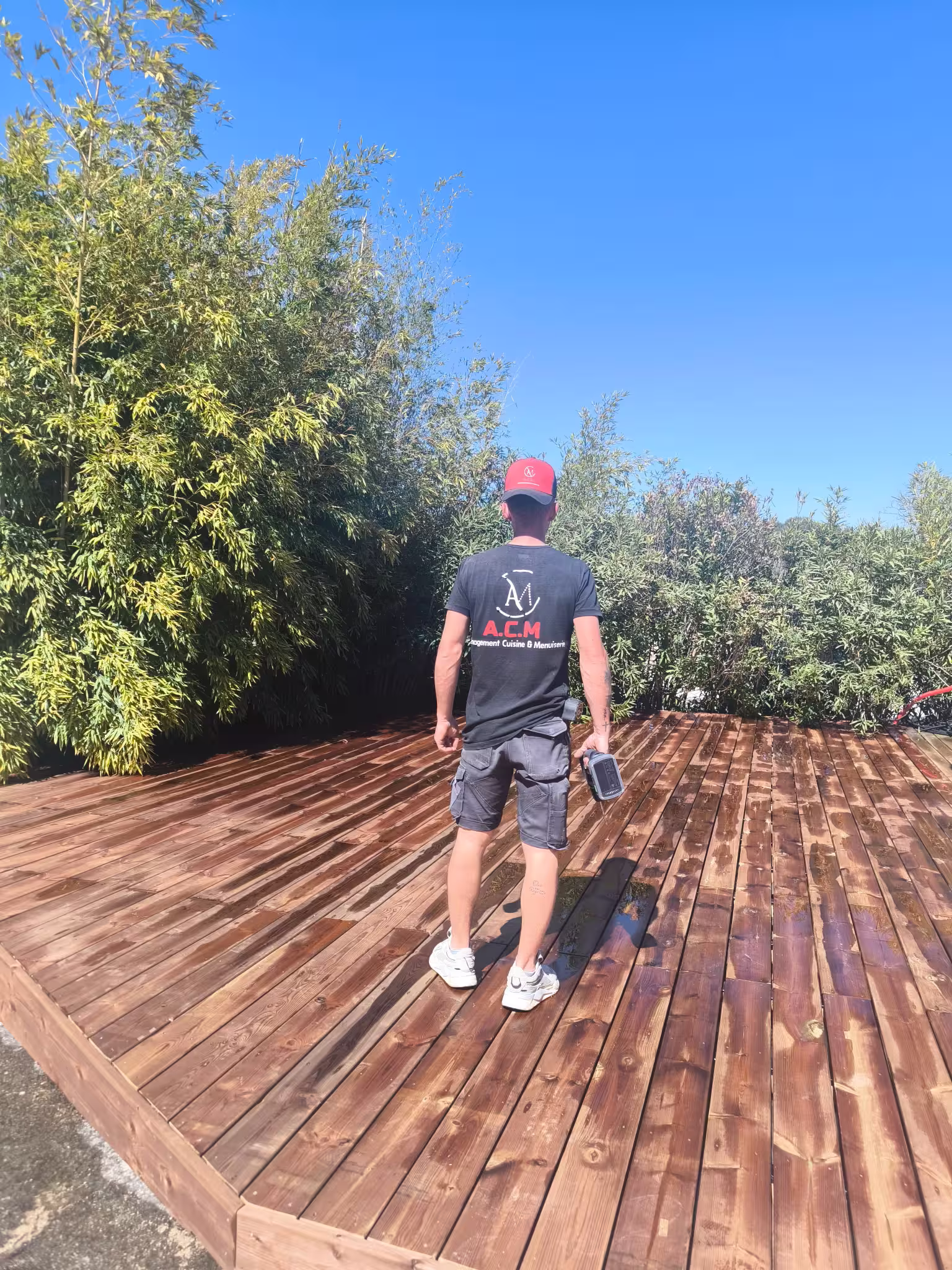 Mickael, artisan ACM Aménagement Cuisine et Menuiserie, sur une terrasse bois
